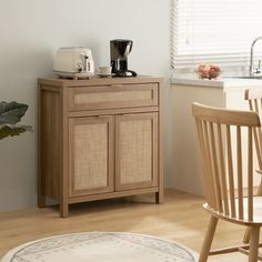 a kitchen area with a table, chair and coffee maker on top of the cabinet