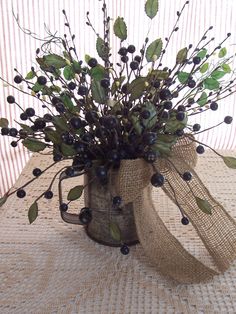 a vase filled with black berries on top of a table