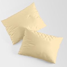 two yellow pillows sitting next to each other