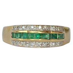 The square cut emeralds in this ring are beautiful and bright and measure 5pts each. Either side of the row of emeralds which are set in a scalloped setting are two rows of diamonds. Each row total approx 10pts of diamonds. The ring is modelled in 18carat gold. Ring Size: O or 7 1/4 Band Width: 6mm Weight: 3.39g Classic Green Multi-stone Diamond Ring, Emerald Cut Green Diamond Ring With Multi-stone, Green Emerald Cut Multi-stone Diamond Ring, Emerald Cut Green Multi-stone Diamond Ring, Emerald Cut Multi-stone Emerald Ring For Anniversary, Emerald-cut Multi-stone Emerald Ring For Anniversary, Classic Green Multi-stone Emerald Ring, Green Multi-stone Baguette Cut Rings, Green Emerald Cut Diamond Ring Channel Set