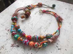 a multi - colored beaded necklace is displayed on a table