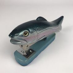 a fish figurine sitting on top of a stapler