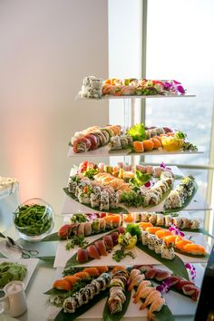 there are many different types of sushi on the table and in the background is a window