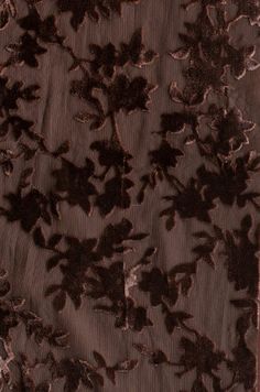 an image of a piece of fabric with flowers and leaves in brown color on black background