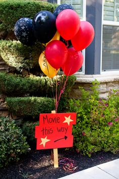 a sign that says move this way with balloons