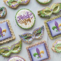 decorated cookies with mardi gras decorations on top of a white countertop,