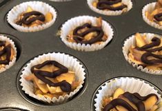 cupcakes with chocolate icing and caramel toppings in the muffin tin