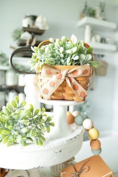 a basket filled with succulents on top of a white table next to boxes