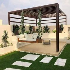 an outdoor living area with grass and white tiles on the floor, covered in plants