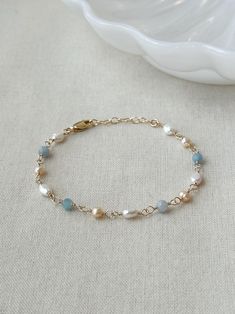 Please review the bracelet sizing guide below for the perfect fit! This dainty genuine Pearl and light blue Aquamarine gemstone bracelet is a gorgeous accents to any special occasion outfit. Each bead is hand wrapped in 14K Gold Filled or 925 Sterling Silver.  * 4mm genuine Aquamarine  * 5-7 mm pink and white Pearls * 14K Gold Filled or 925 Sterling Silver accents * 14/20 GF for authenticity * Adjustable fit: 6.75" with 1" extender chain  *Natural pearls will vary slightly in shape and color Bracelet Sizing Guide: 5-6.5 inches = xtra small 6.5-7 inches = small 7-8 inches = medium 8 inches+ = large Each Bracelet is measured held taught from tip to end. Unsure what size to choose? The best way to find the right size is to take a string (even floss) and measure your wrist, then add 1/2 to a f Small Bead Bracelet, Bead Bracelet Ideas, Pearls Bracelet, Bracelet Elegant, Occasion Outfit, Aquamarine Bracelet, Color Bracelet, Basic Jewelry, Bracelet Wedding