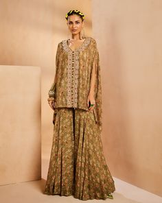 It features an easy vintage floral kaftan top with gharara pants. The kaftan has a very intricately fully hand-embroidered border panel with colorful Japanese bugle beads, sequences, and cutdana. The kaftan is accentuated with colorful bead stones.From Aneesh Agarwaal's Seher collection.DELIVERY TIMEPlease allow 8-12 weeks for your outfit to arrive.FABRIC DETAILSChinonProfessional cleaning only. Bohemian Georgette Sharara For Reception, Traditional Embellished Green Palazzo Set, Festive Zari Work Tunic Set, Sets With Dupatta And Tunic Shape For Festivals, Bohemian Palazzo Set With Dupatta For Festive Occasions, Bohemian Palazzo Set With Dupatta For Festive Season, Tunic Sets With Dupatta For Festivals, Festive Bohemian Palazzo Set With Dupatta, Silk Tunic Sets For Wedding