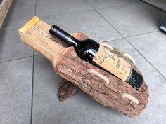 a bottle of wine sitting on top of a piece of wood with a cork in it