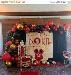 a stage set up for a birthday party with balloons and decorations on the floor,