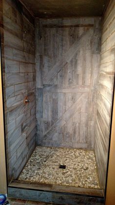 a walk in shower sitting inside of a bathroom next to a tiled floor and walls