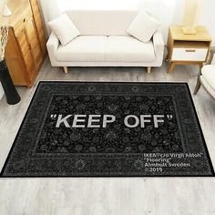 a black rug with the words keep off on it in front of a white couch