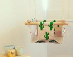 a bathroom with a cactus print towel hanging from the ceiling and two cups on the counter