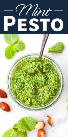 pesto in a small glass jar with basil leaves and almonds on the side