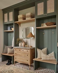 a room filled with lots of wooden furniture and green cupboards next to a rug