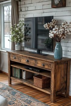 a living room with a large tv on top of a wooden stand