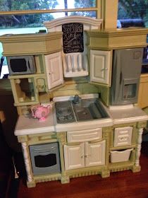 a toy kitchen is shown in front of a window