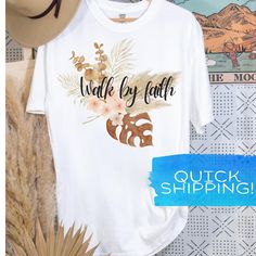 The "Walk by Faith Walk with Jesus" women's graphic Bible tee shirt is a stylish boho scripture shirt. This boho graphic Bible verse shirt is perfect for both her and him, combining faith and fashion. DETAILS: 🪶 Comfort Colors - vintage style tshirt for that lived-in look 🪶 True to size but slightly oversized style. 🪶 Please consult the color chart for color choices. 🪶 Preshrunk fabric ensures a retained fit and style. CARE INSTRUCTIONS: 🪶 Machine wash inside out with like colors. 🪶Tumble Inspirational Graphic Print T-shirt For Summer, White Bohemian T-shirt For Vacation, Bohemian Relaxed Fit T-shirt With Letter Print, Bohemian Graphic Print T-shirt For Vacation, Inspirational Summer Graphic T-shirt, White Bohemian T-shirt With Letter Print, Bohemian Custom Print T-shirt For Summer, Inspirational Summer Graphic Print T-shirt, Floral Arrow Christian Shirt