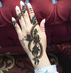 a woman's hand with henna tattoos on it