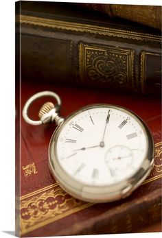 an old pocket watch sitting on top of a book