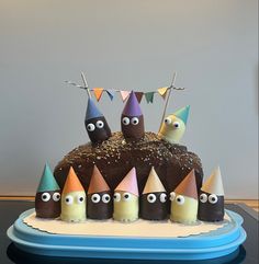 a birthday cake with chocolate frosting and colorful decorations on the top, surrounded by eyes