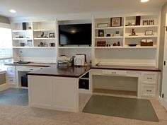 a home office with built - in shelving and desks