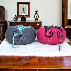 two pink and grey bags sitting on top of a white rug in front of a mirror