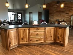 a large kitchen with wooden cabinets and black counter tops, along with two white chairs