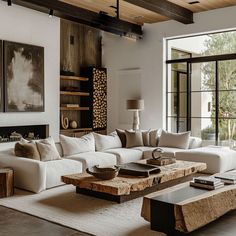 a living room filled with white couches and wooden tables in front of large windows