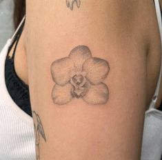 a woman with a tattoo on her arm has a flower in the shape of a heart