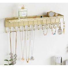 a shelf with many necklaces hanging from it's sides and a clock on top