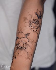 a woman's arm with black and white flowers on it