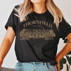 Jane Eyre shirt for fans of Charlotte Bronte and the Bronte sisters. Enjoy your Mr Rochester merch as a Thornfield Hall tribute. The perfect bookish gift or book club sweater to show your love for the romance classics. Browse through our store here: https://chapterkeepers.etsy.com ★ SIZING ⮕ Please check the size chart in the listing photos! ⬅ This shirt (Bella Canvas 3001) is unisex and true to size, with a relaxed fit. If you prefer a slimmer fit, consider a smaller size. Contact us if you have a special request. If you would like this design on a v-neck shirt, youth kid's shirt, hoodie, sweatshirt, long-sleeve shirt, tank top, mug, or anything else, please send us a message! ★★ PRODUCTION & SHIPPING TIME  ＊ Production time: 2-7 business days  ＊ US Shipping time: 3-6 business days  ＊ Int Black Literary Top With Graphic Print, Mr Rochester, Jane Austen Gifts, Charlotte Brontë, Bronte Sisters, V Neck Shirts, Charlotte Bronte, College T Shirts, Mr Darcy