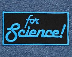 a blue and black patch with the words for science written in white letters on it