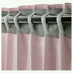 pink and grey curtains hanging on the side of a curtain rod with metal grommets