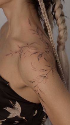 a woman with a bird tattoo on her shoulder