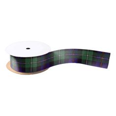 a green and purple plaid ribbon on a white background with a roll of tape next to it