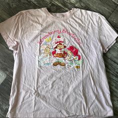 This Retro Style T-Shirt Has Strawberry Shortcake On The Front. In Excellent Used Condition. * Item Pictured Is The Exact Item You Will Receive. * Photos Will Show Any Wear Or Tear To Item. * Item Comes From A Smoke Free Home. * Item Has Been Sanitized, And Repackaged For Shipment, Unless Item Is New With Tags. Sweet Cartoon Print Short Sleeve Tops, Sweet Cartoon Print Crew Neck Top, Sweet Cartoon Print Cotton Tops, Sweet Tops With Funny Print And Crew Neck, Sweet Cotton Tops With Cartoon Print, Sweet Graphic Print Crew Neck Tops, Sweet Style Crew Neck Tops With Graphic Print, Sweet Cartoon Print Crew Neck T-shirt, Sweet Style Crew Neck T-shirt With Cartoon Print