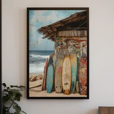 surfboards are lined up against the wall in front of a hut on the beach