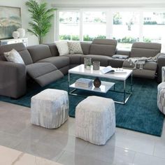 a living room filled with lots of furniture in it's centerpiece and large windows