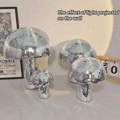 three shiny disco balls sitting on top of a table next to a framed photograph and clock