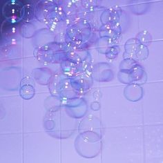 soap bubbles floating in the air on a tiled wall