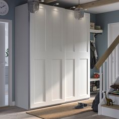 a room with some white doors in it and a clock on the wall above them