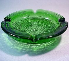 a green glass bowl sitting on top of a table