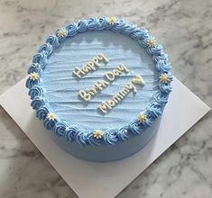 a blue frosted birthday cake sitting on top of a table