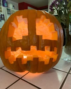 a carved pumpkin sitting on top of a tiled floor