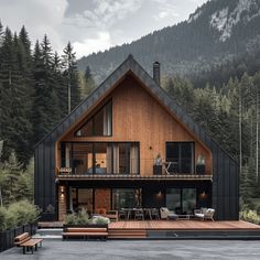 a wooden house in the middle of a forest with lots of trees and mountains behind it